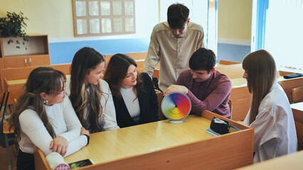 Students in physics class spin Newton's multicolored disk.