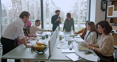 Mixed race team of businesspeople or workers engaging in a brainstorming session, exchanging ideas or strategizing for growth in a modern office environment. - Powered by Adobe