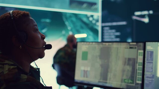 Woman military personnel tracking enemy vessels on the coast line territory, working on national safety and providing real time data to the dispatch center. Reconnaissance system. Camera B.