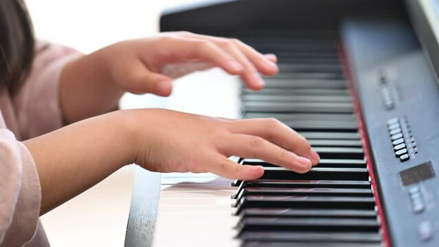 Child playing piano Close-up video of girl's hand