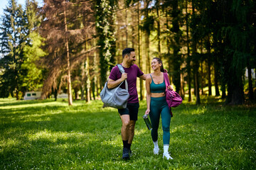 Fototapeta premium Happy athletic couple talkin while walking in park.