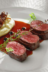 Medium-rare venison steak with mashed potatoes on a plate