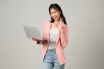 happy asian woman wearing formal casual outfit holding laptop computer giving approval ok sign gesture on isolated background