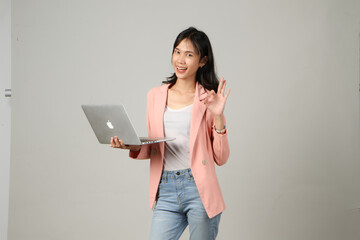 happy asian woman wearing formal casual outfit holding laptop computer giving approval ok sign gesture on isolated background