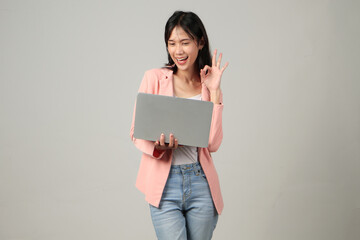 happy asian woman wearing formal casual outfit holding laptop computer giving approval ok sign gesture on isolated background