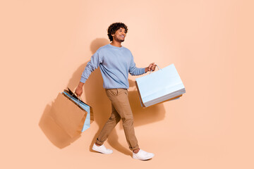 Full size photo of nice guy dressed blue pullover trousers walk with shopping bags look empty space...