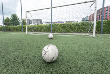 Green grass and white border lines on football ground. Soccer field on artificial turf. Artificial green grass texture. Artificial football field in an open stadium