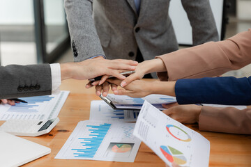 Close-up shots of teamwork at a meeting Businessman analyzes cost graph on desk at conference room in office