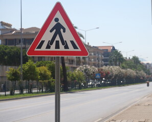 a busy highway with a curb in the city with green spaces and a dividing metal mesh 2