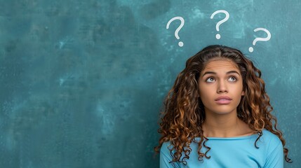 A woman in a blue top with question marks above her head, girl is thinking , confused 