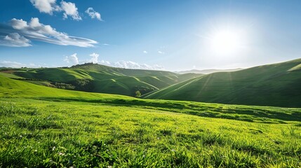 Lush green rolling hills under a clear blue sky with sunlight and scattered white clouds on a bright summer day in a tranquil countryside landscape