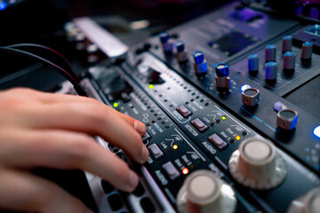 close up the recording room dark with neon lighting in the studio the sound engineer works with the remote control and adjusts the sound