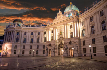 Vienna, Austria, August 17, 2022. Magnificent night view of the Hofburg Imperial Palace, the illumination enhances the imposing facade. People in the square.