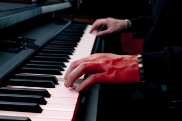 Obraz premium close up in the recording room dark studio sound engineer while playing, records the sound of synthesizer selecting the desired k