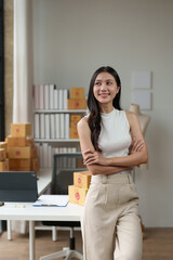 Independent business woman Asian freelance female employee smiling brightly Standing with arms crossed confidently, happy standing in the office, working online. Parcel shipping.
