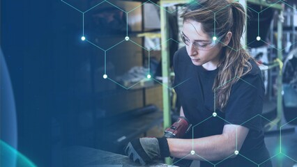 Naklejka premium Female mechanic drilling into metal