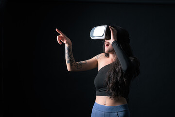 Woman wearing virtual reality headset against dark background