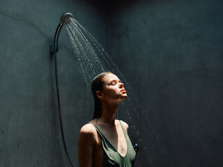 Relaxing moment in the shower as water flows from the faucet over a woman's body