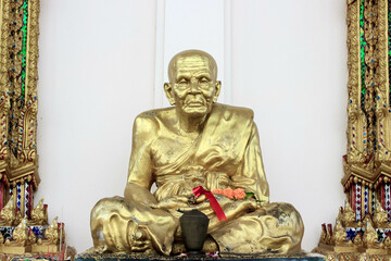 A Golden Monk Statue in a decorated temple symbolizes ancient traditions and spirituality