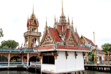 Gaze at the stunning details of a Thai temple near the river, showcasing elaborate architecture