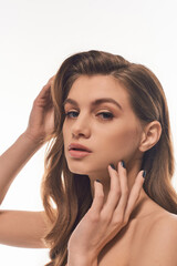 Fototapeta premium A young, beautiful woman with long wavy hair exuding an aura of mystery and allure.