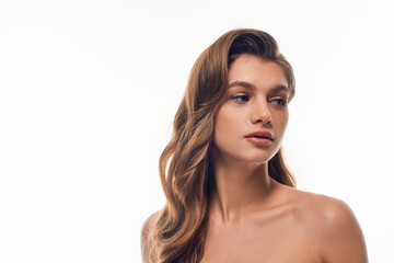Naklejka premium A stunning young woman with long wavy hair strikes a pose for a photo, exuding grace and beauty.