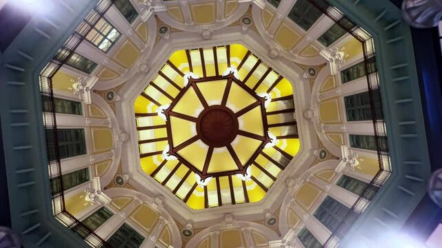 Ornate ceiling with intricate design and warm lighting from a low angle