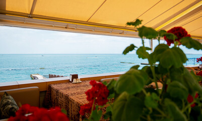 Restaurant or cafe on outdoor terrace with view of see. Tourism and travel. Enjoying life. Beautiful places.
