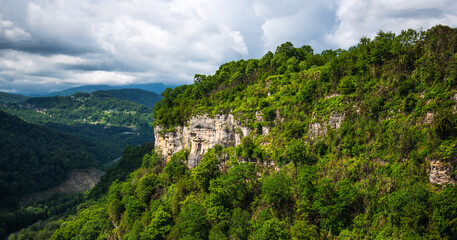 View of a beautiful mountainous area. Sunny afternoon. Beautiful spring landscape in the mountains. Rocks and dense forest.