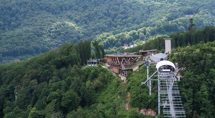 View of a suspension bridge in mountains. Travelers crosses hiking on an impressive metal bridge.