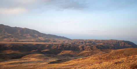 Fototapeta premium Autumn landscape of vast plains in China. Breathtaking, amazing, endless desert mountain landscapes bordering the Gobi Desert.
