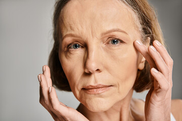 A mature, attractive woman in comfortable attire, expressing emotions by placing her hands on her...