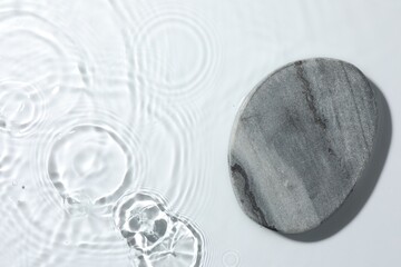 Presentation of product. Stone podium in water on white background, top view. Space for text