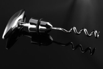 One metal corkscrew on dark mirror surface, closeup