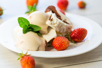 fresh organic cottage cheese with strawberries and ice cream in a plate on a wooden table
