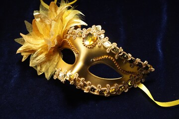 Theater arts. Golden venetian carnival mask on blue fabric