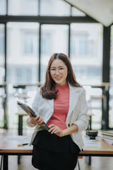 Attractive Asian businesswoman working at modern office with balance sheet documents. Accounting