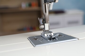 White sewing machine on blurred background, closeup