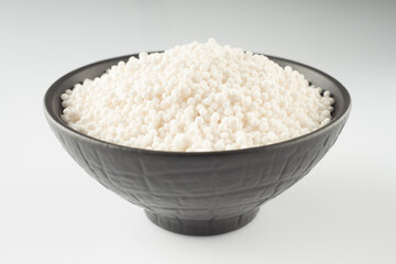 White Sago Pearls in Dark Bowl Also Know as Sabudana, Tapioca Pearl or Sago Seeds isolated on White Background