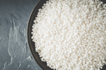 White Sago Pearls in Dark Bowl Also Know as Sabudana, Tapioca Pearl or Sago Seeds isolated on Gray Background. Top view