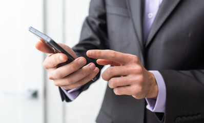 Businessman in the suit is using smartphone