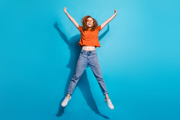 Photo of positive cheerful girl jump up feel carefree isolated blue color background