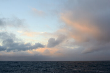 Calm Ocean at Sunset with Dramatic Clouds