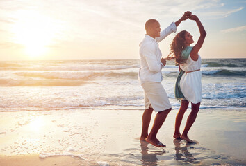 Couple, celebration and dance on beach with outdoor romance, holiday and vacation by ocean sunset....
