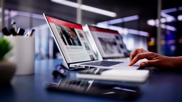 American Woman Views Online News Articles on Laptop and Phone While Relaxing on Sofa in Black