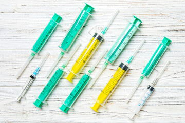 Top view of many syringes prepared for injection at wooden background. Treatment concept with copy space