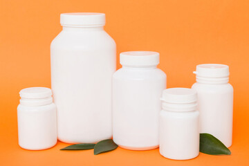supplement pills with medicine bottle health care and medical top view. Vitamin tablets. Top view mockup bottle for pills and vitamins with green leaves, natural organic bio supplement, copy space