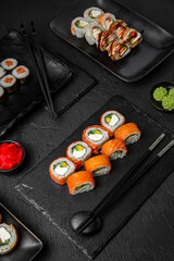 Sushi set composition on black background. The Art of Japanese Cuisine. Food photography for menu and sushi bar decoration