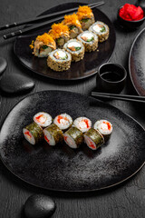 Sushi set composition on black background. The Art of Japanese Cuisine. Food photography for menu and sushi bar decoration