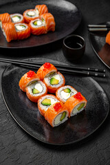 Sushi set composition on black background. The Art of Japanese Cuisine. Food photography for menu and sushi bar decoration